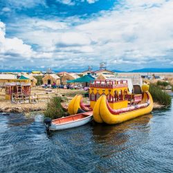 Uros, Peru - Jan 5, 2019. Traditional Totora boat with tourists on Titicaca lake near to the Uros floating islands , Puno, Peru, South America.